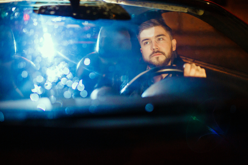 man driving at night thanks to night driving tips