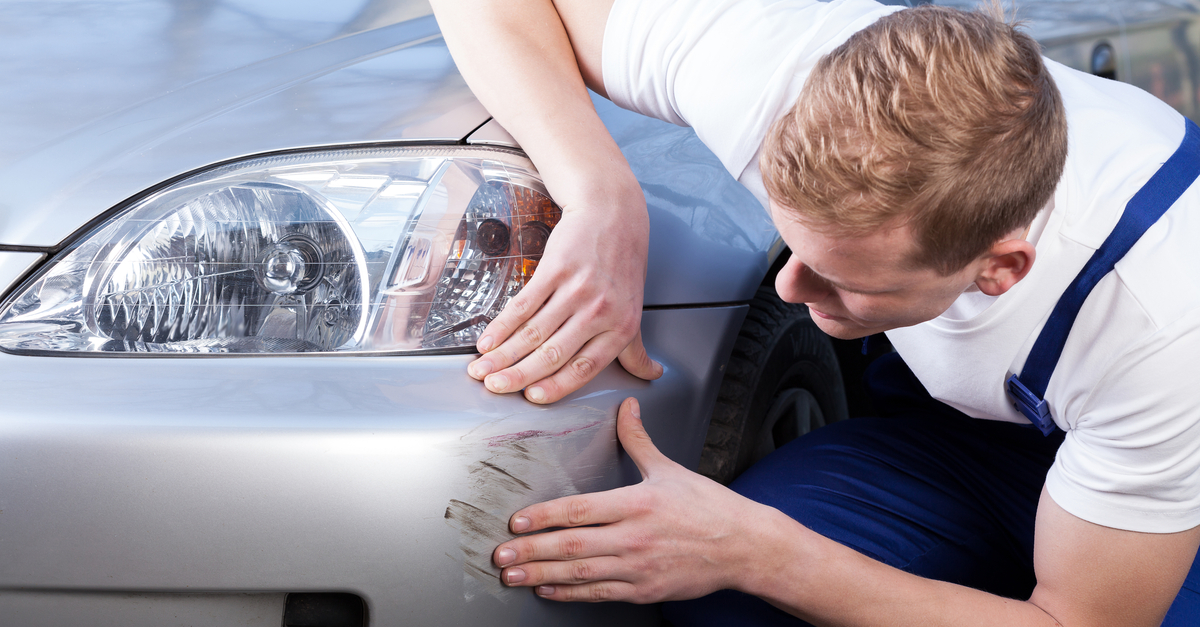 man looking at a scratched car